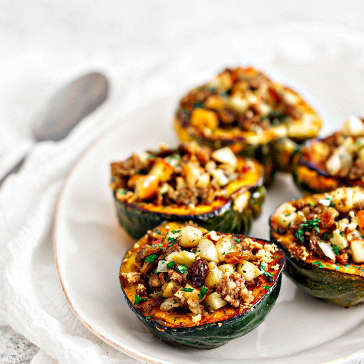 white platter with sausage and apple stuffed acorn squash