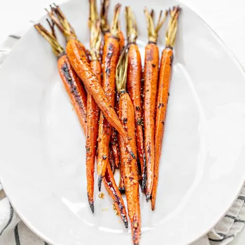 whole roasted carrots on white plate