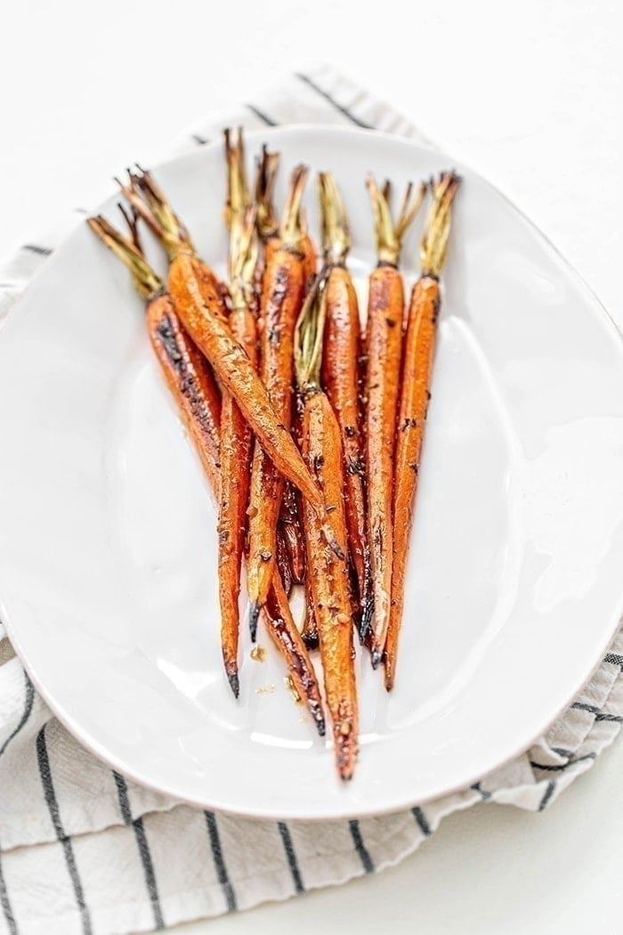 whole roasted balsamic carrots on white plate