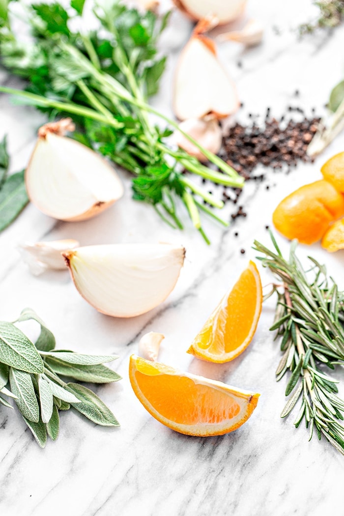 Orangenscheiben und frische Kräuter auf weißem Hintergrund
