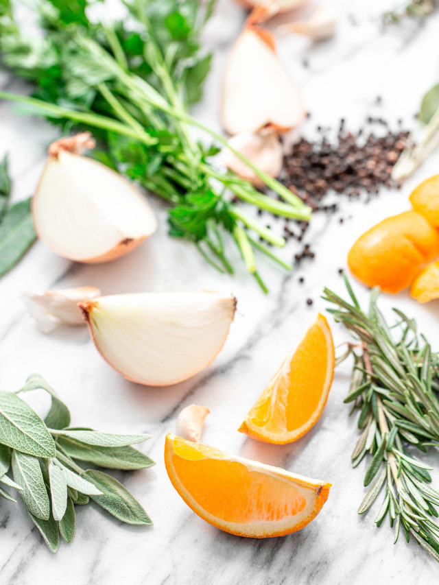 ingredients in citrus turkey brine: orange slices and fresh herbs on white background