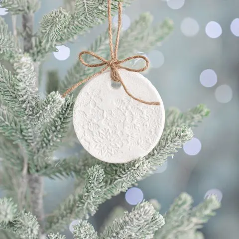 salt dough ornament on a christmas tree with lights