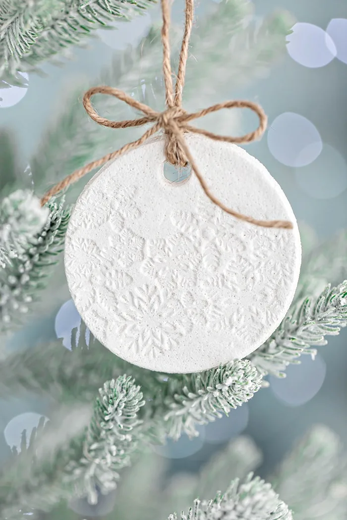photo of a homemade salt dough ornament hanging on a christmas tree with white lights