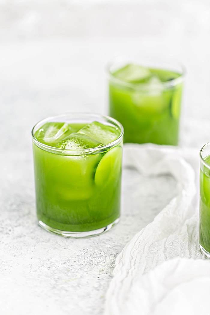 3 glasses of green juice spinach juice recipe on white background