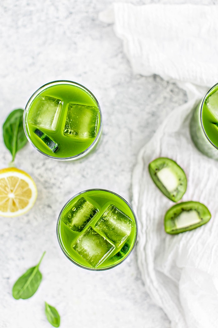overhead image of 3 glasses with spinach juice on a white background