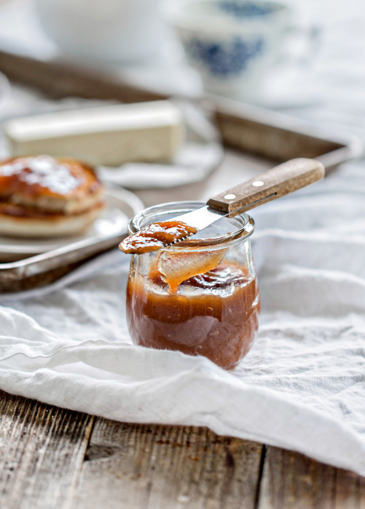 wooden table set with breakfast and a jar of pear butter