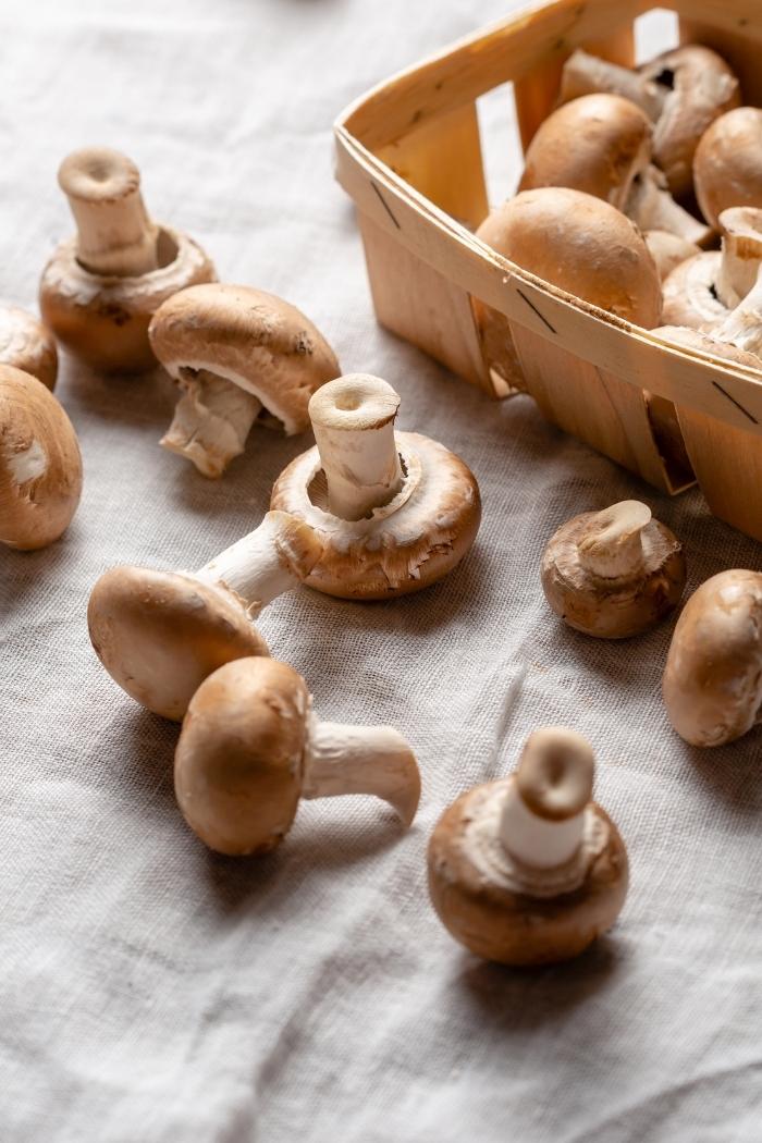 photo of mushrooms in a basket on a tea towel for a mushrooms and green bean recipe