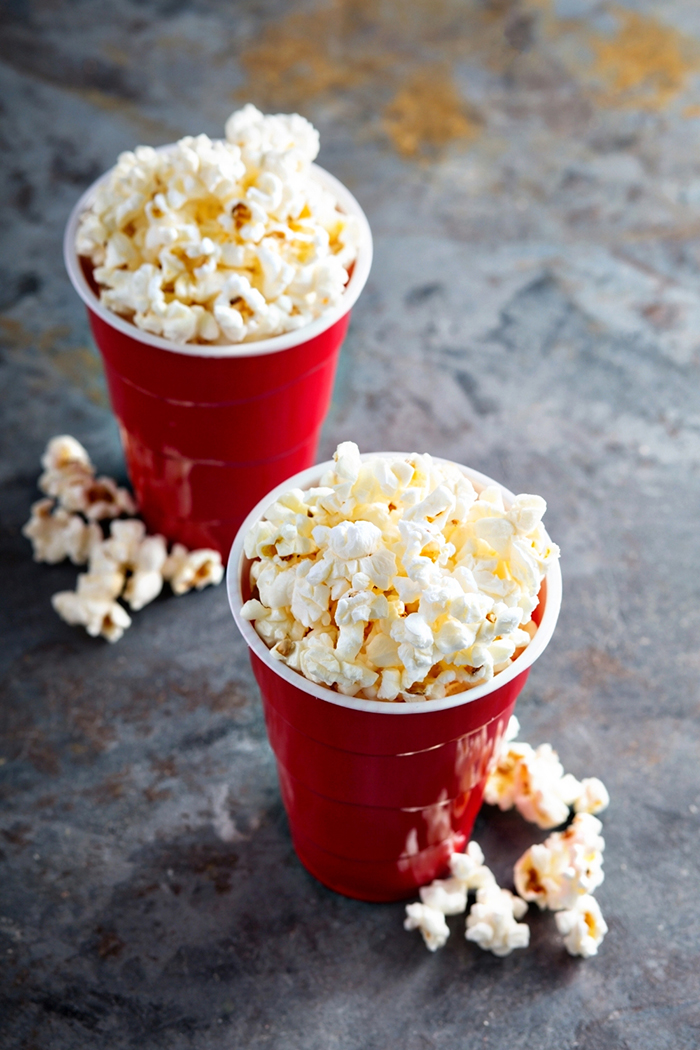 2 red cups with popcorn in them