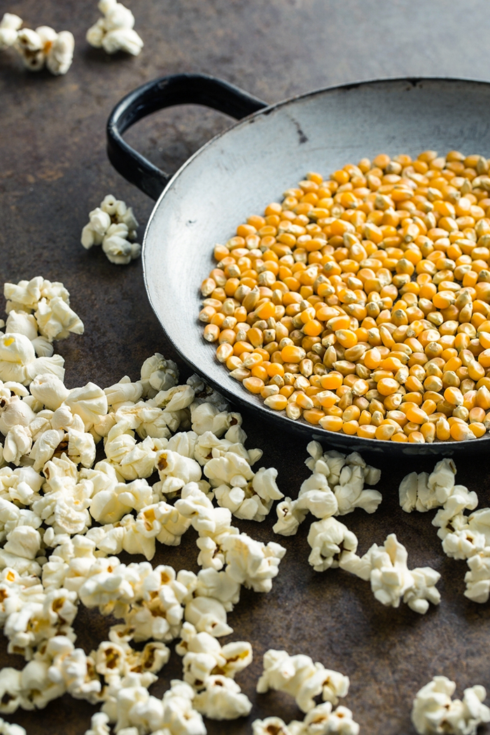 bowl of popcorn kernels next to popcorn