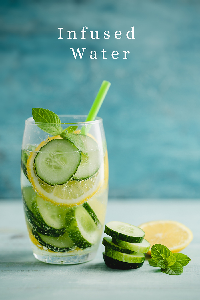 glass with water, lemons, and cucumber