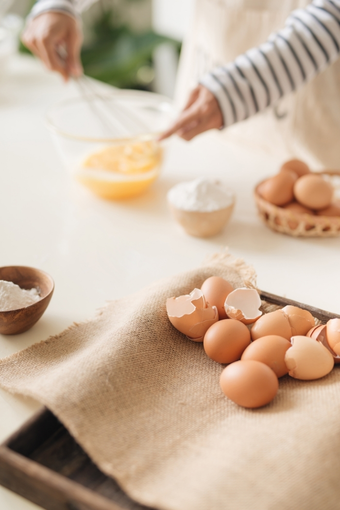 whisking eggs in a glass bowl on a kitchen counter