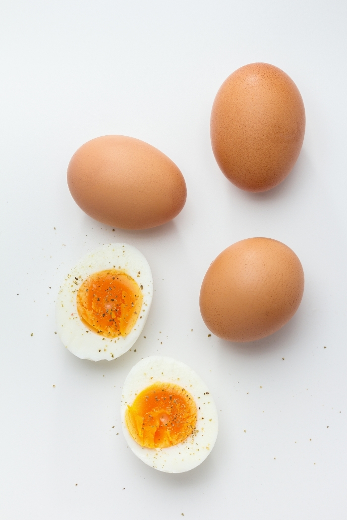 white background with brown eggs and a hard boiled egg