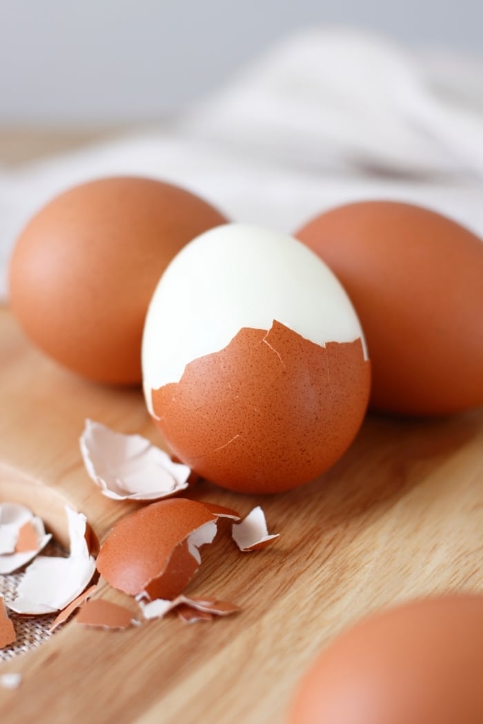 brown hard boiled eggs being peeled