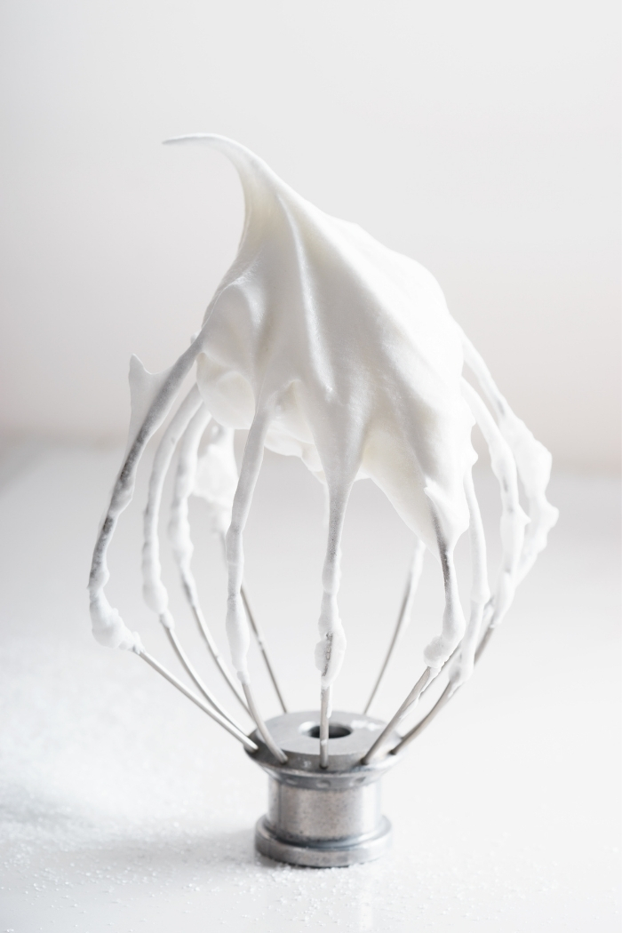 a photo of whipped cream on a wire beater for making strawberries and cream