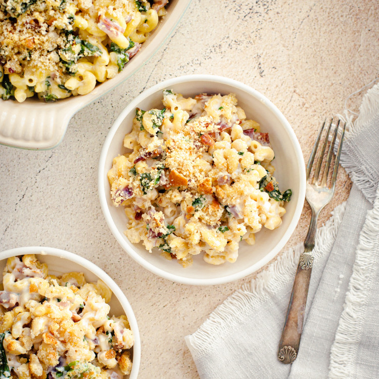 overhead photo of bowl of white cheddar mac and cheese next to a fork and napkin