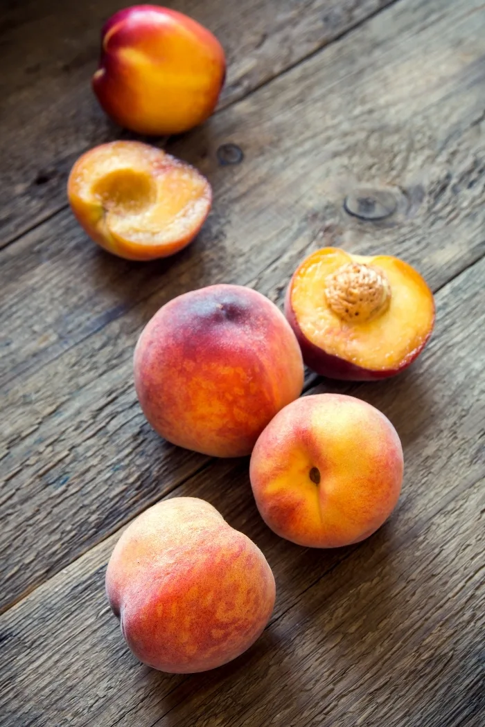 a photo of fresh peaches on a wooden table before making grilled peaches with mascarpone