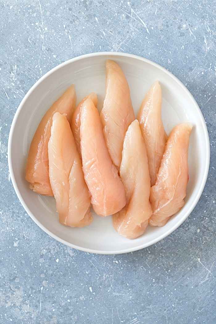 chicken tenderloins in a white bowl