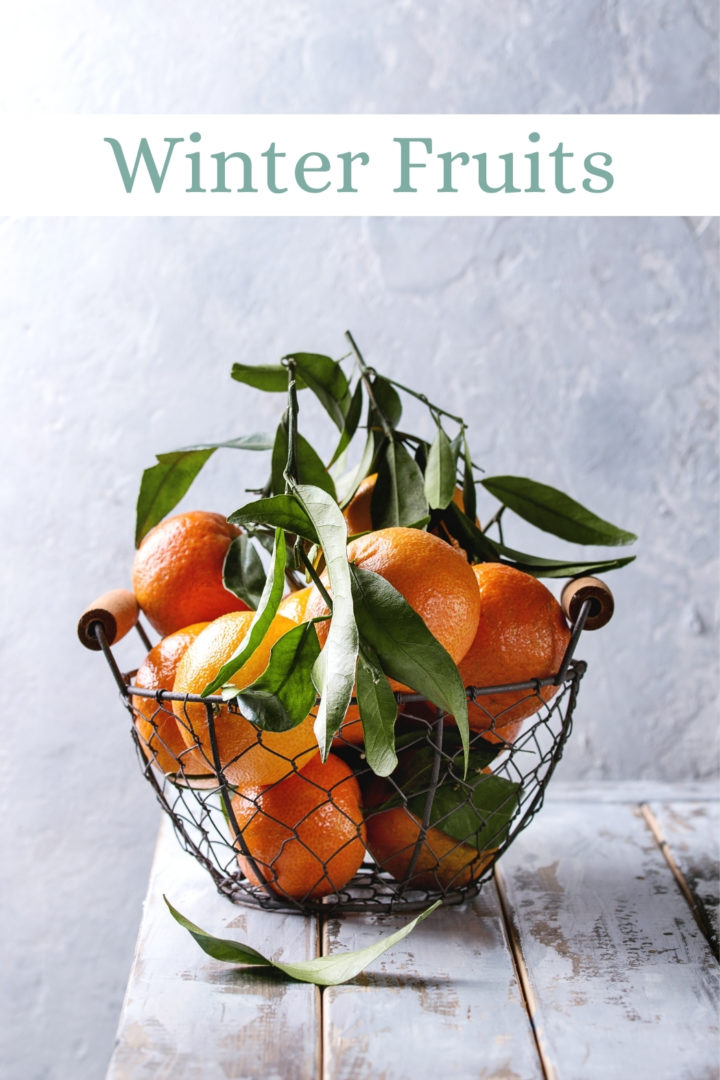 photo of clementines in a wire basket on a farmhouse table showing winter fruit