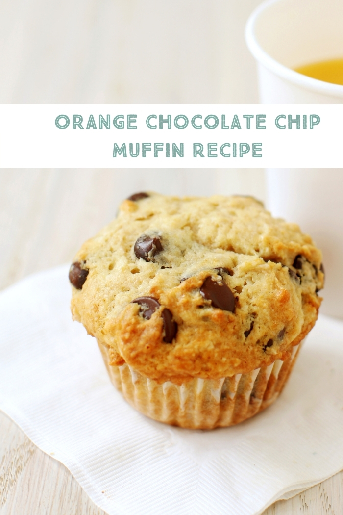orange chocolate chip muffin on a napkin with a glass of orange juice