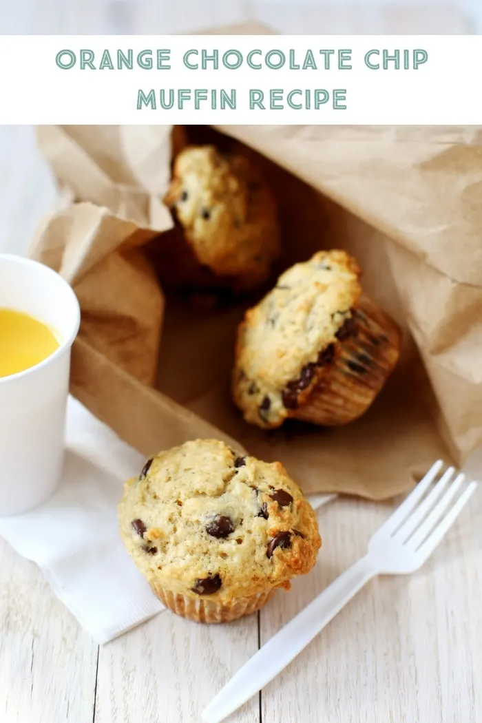 orange chocolate chip muffins in a brown paper bag on a table