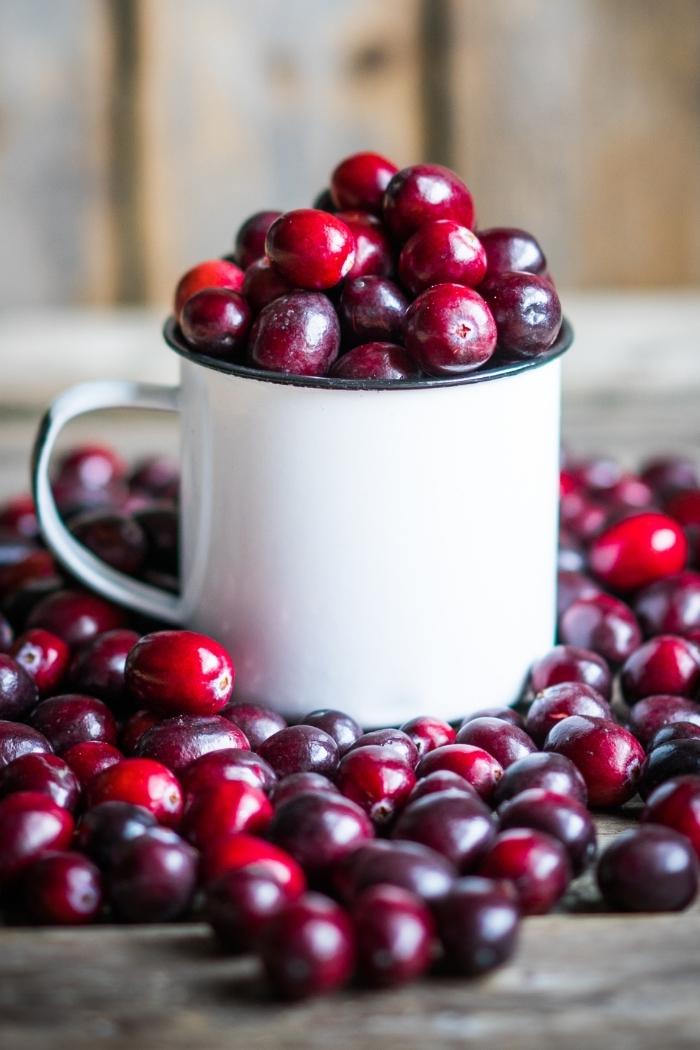 cranberries in a white mug on a rustic background