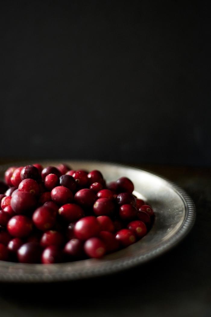 cranberries in a metal bowl on a dark background