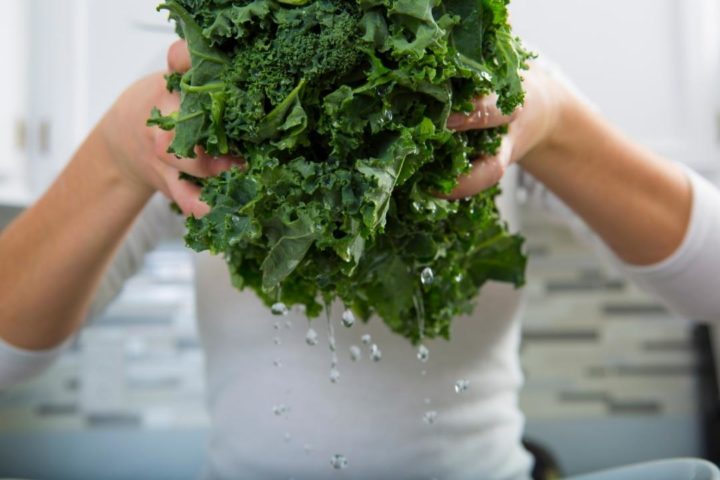 woman washing kale leaves to prepare to freeze kale