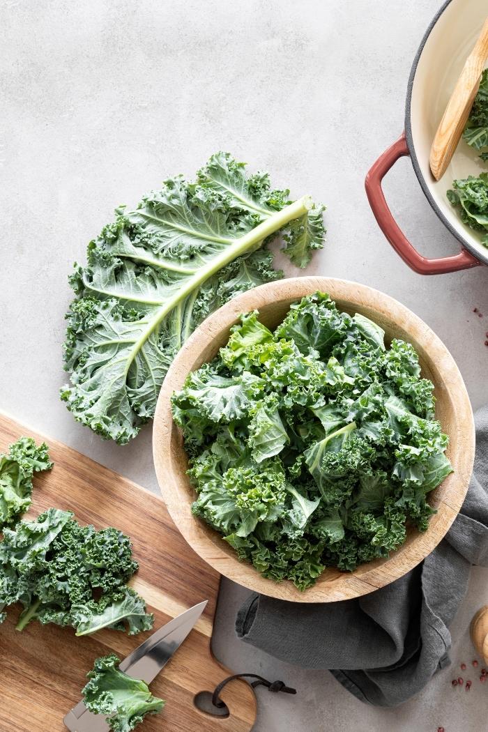 overhead shot of kale leaves on a cutting board and in a bowl