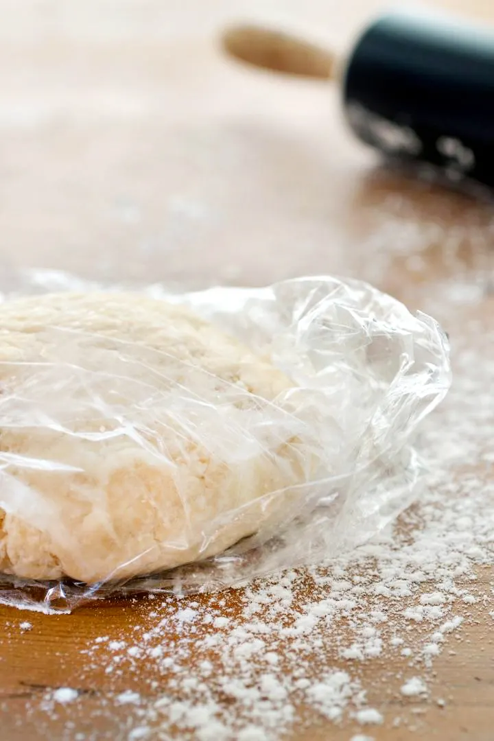 wrapped pie dough with a rolling pin in the background