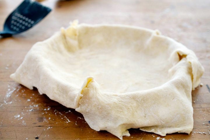 pie dough in a pie plate getting ready to be shaped