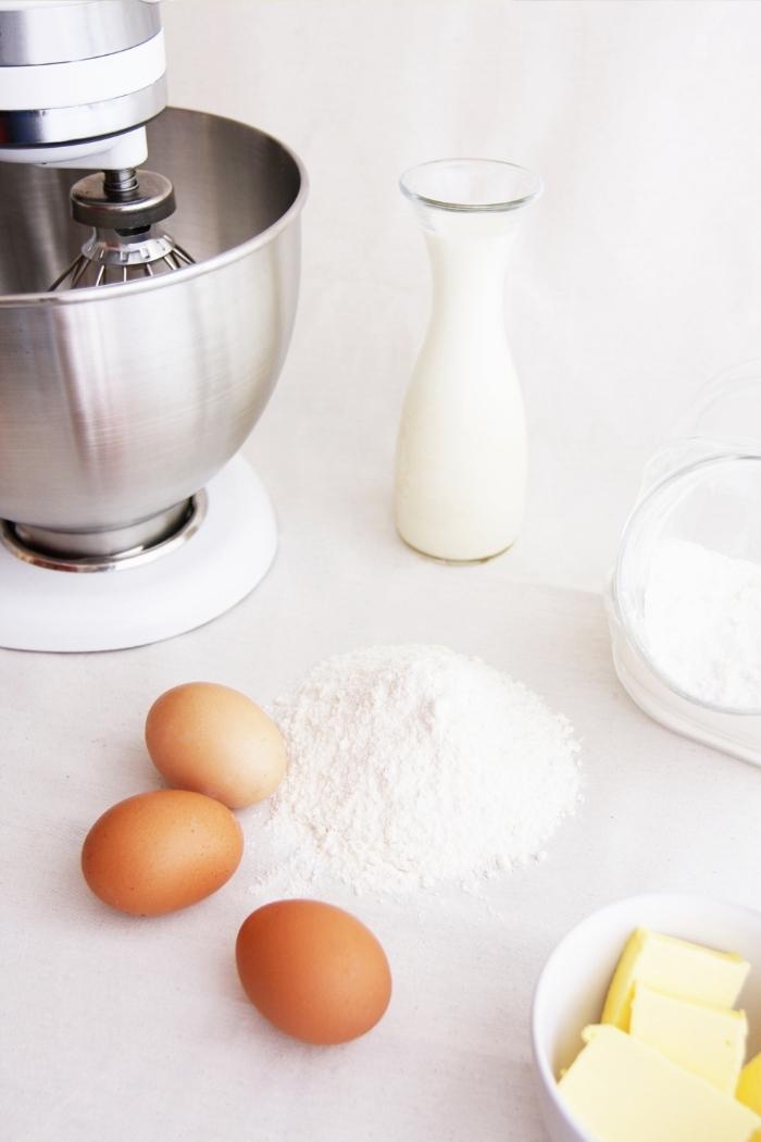 eggs and a mixer with baking supplies on counter