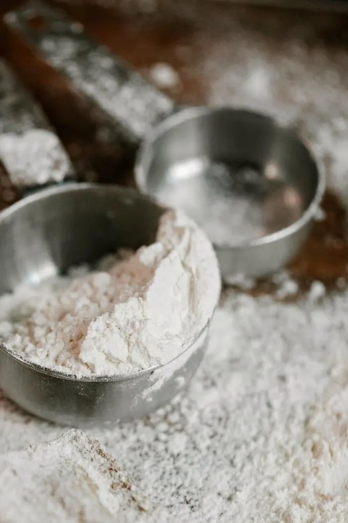 metal measuring cup with flour
