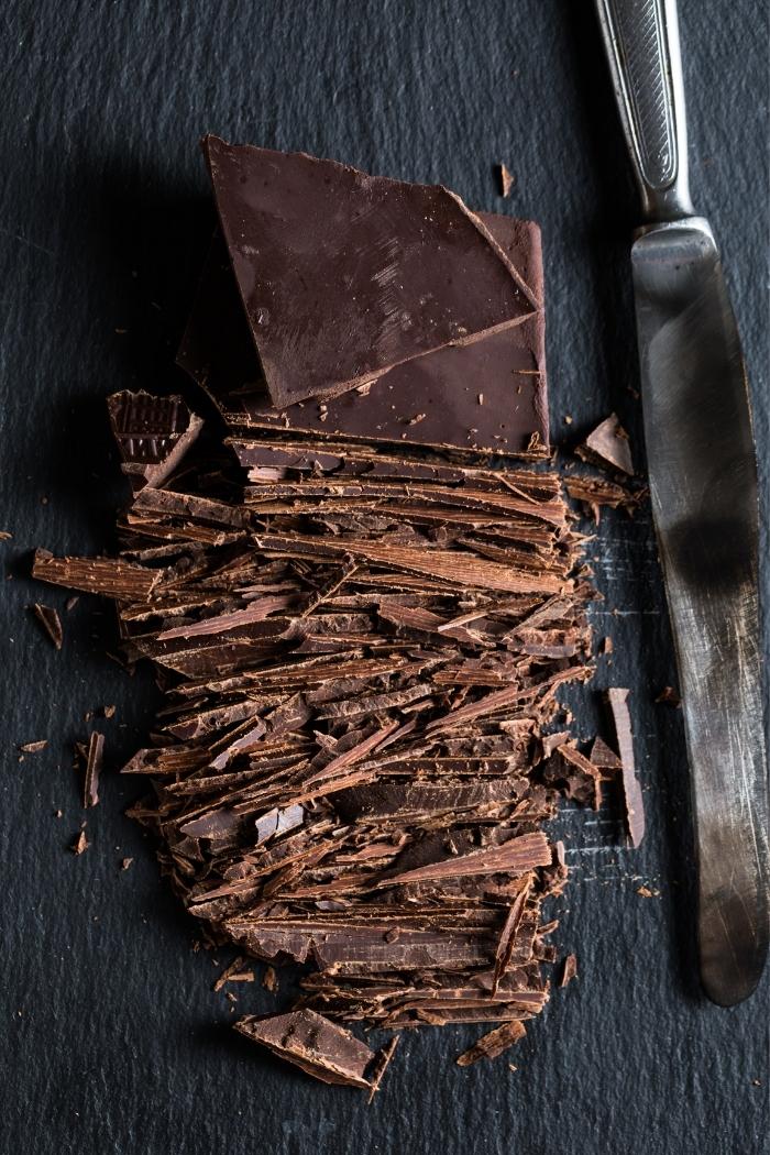 chopped chocolate bar with knife on dark background