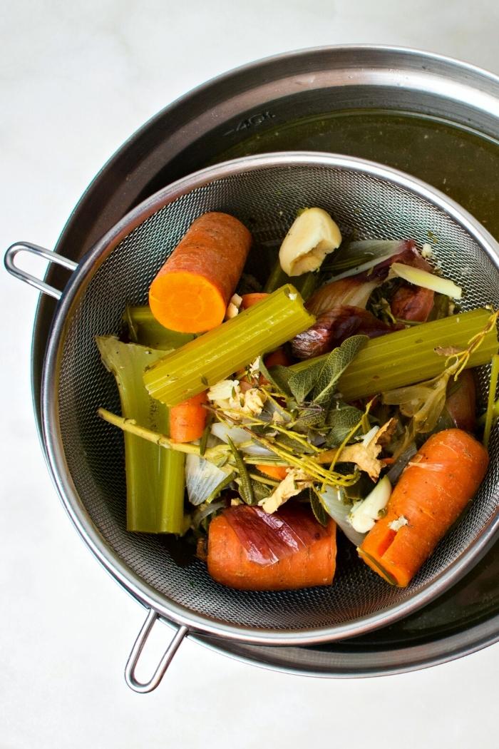 strainer over a pot straining vegetable broth to show a step in how to make vegetable broth