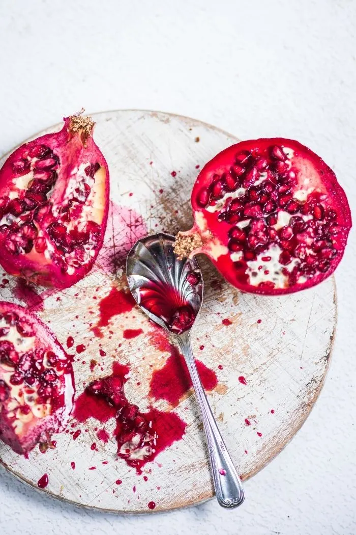 cut pomegranates on a white cutting board