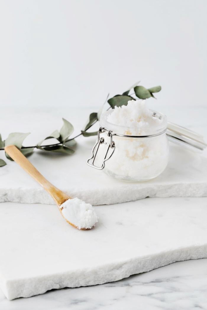 jar of rosemary mint sugar scrub on a marble counter