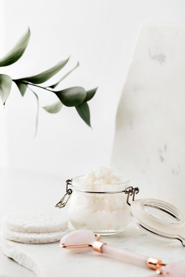 jar of rosemary mint sugar scrub on a marble counter