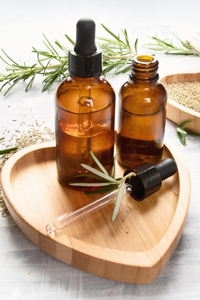 brown dropper bottles of rosemary essential oil for making homemade sugar scrub recipes