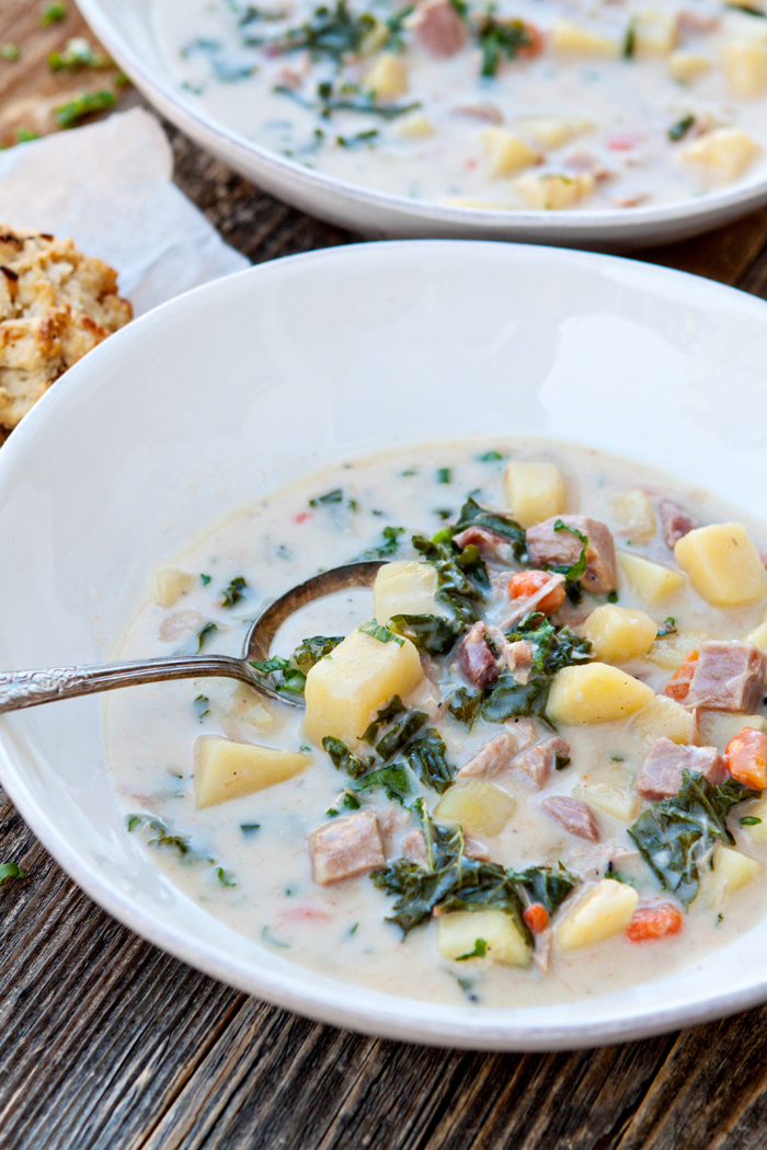 a white bowl of ham soup on a wooden table