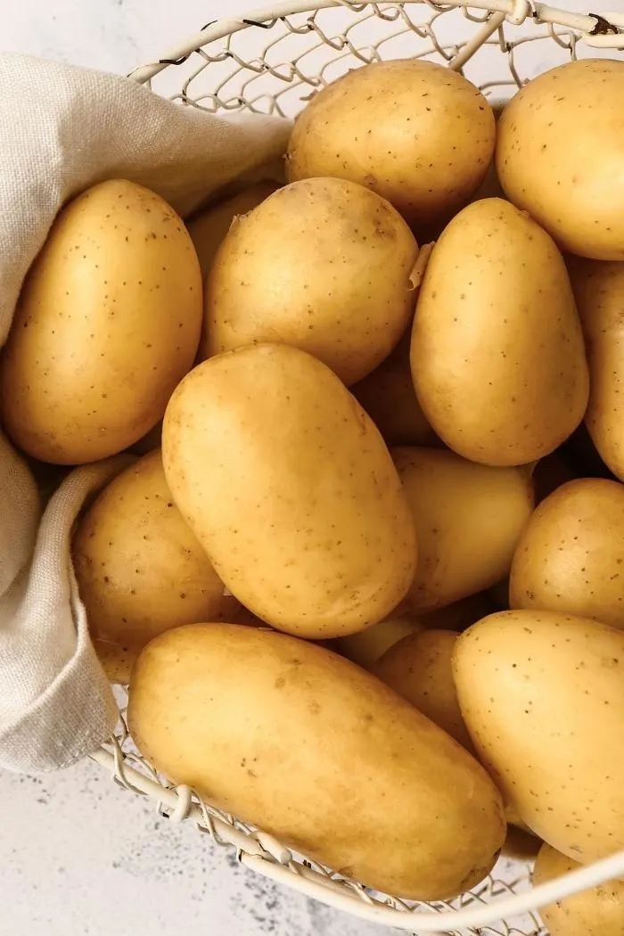 close up of potatoes for potato salad in a metal basket