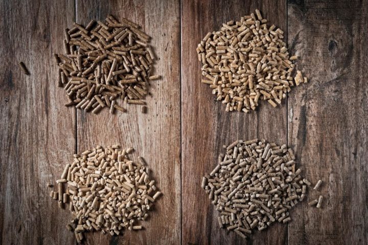 photo of different types of pellet grill pellets used for making smoked pork shoulder on wood background