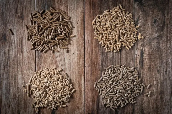 photo of different types of pellet grill pellets used for making smoked pork shoulder on wood background