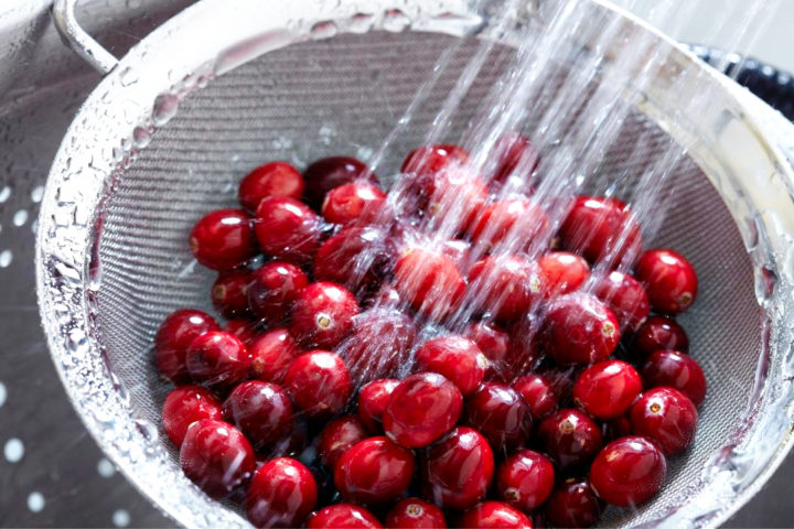 rinsing cranberries in a strainer before freezing