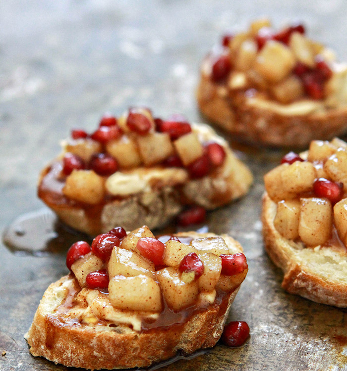 pear and pomegranate crostini on a baking sheet