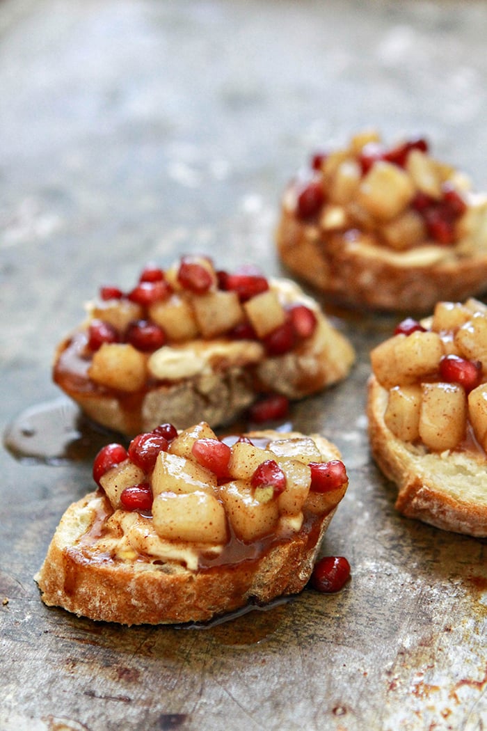 pomegranate and pear crostini appetizers on a baking sheet