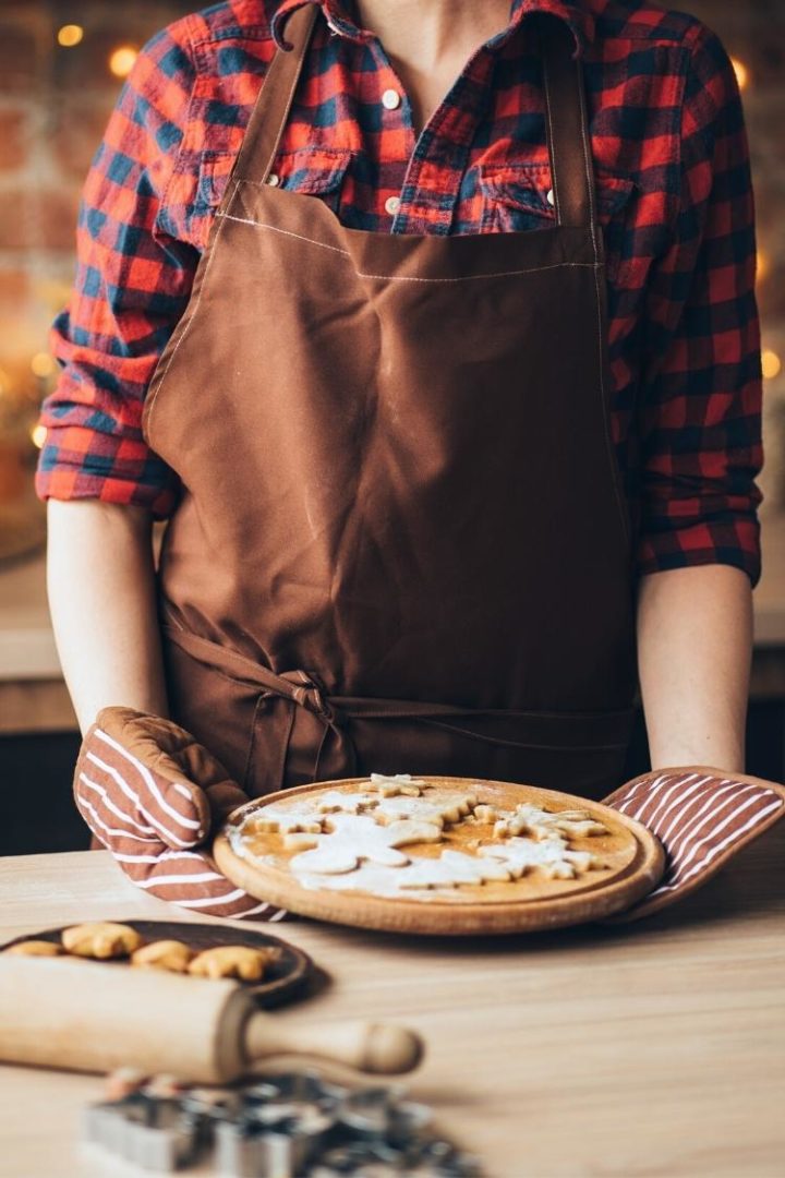 woman holding christmas cookies on a cutting board