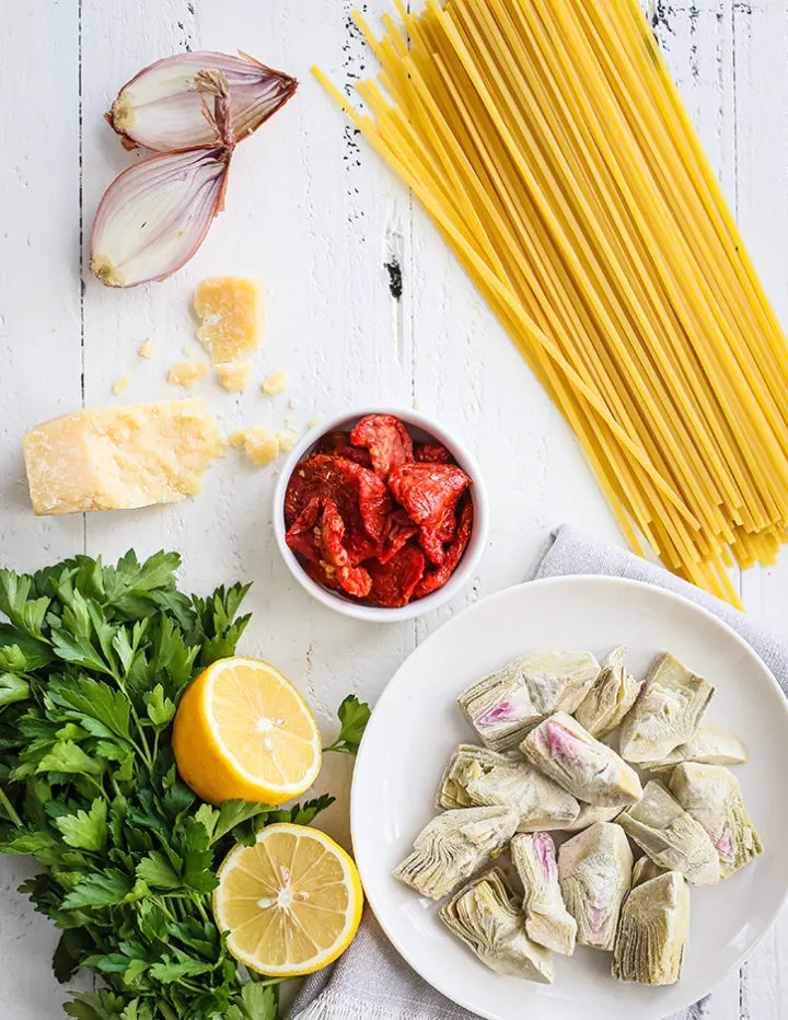 overhead shot of ingredients to make shrimp scampi on a white farmhouse table