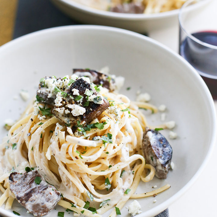 overhead image of gorgonzola pasta with beef in a white bowl