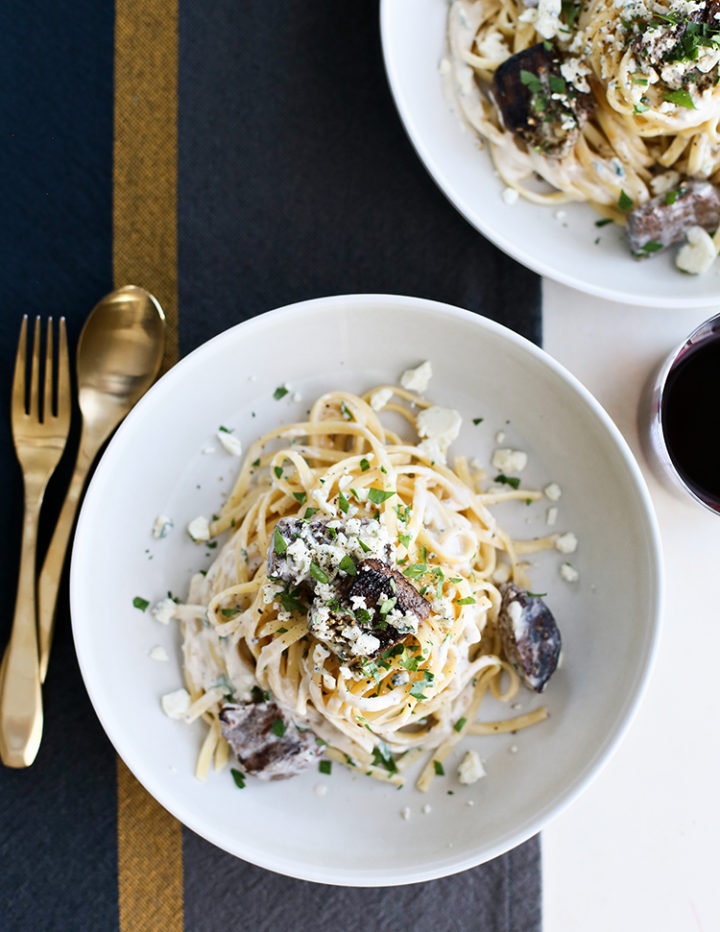 overhead shot of gorgonzola pasta with beef tenderloin in a white bowl