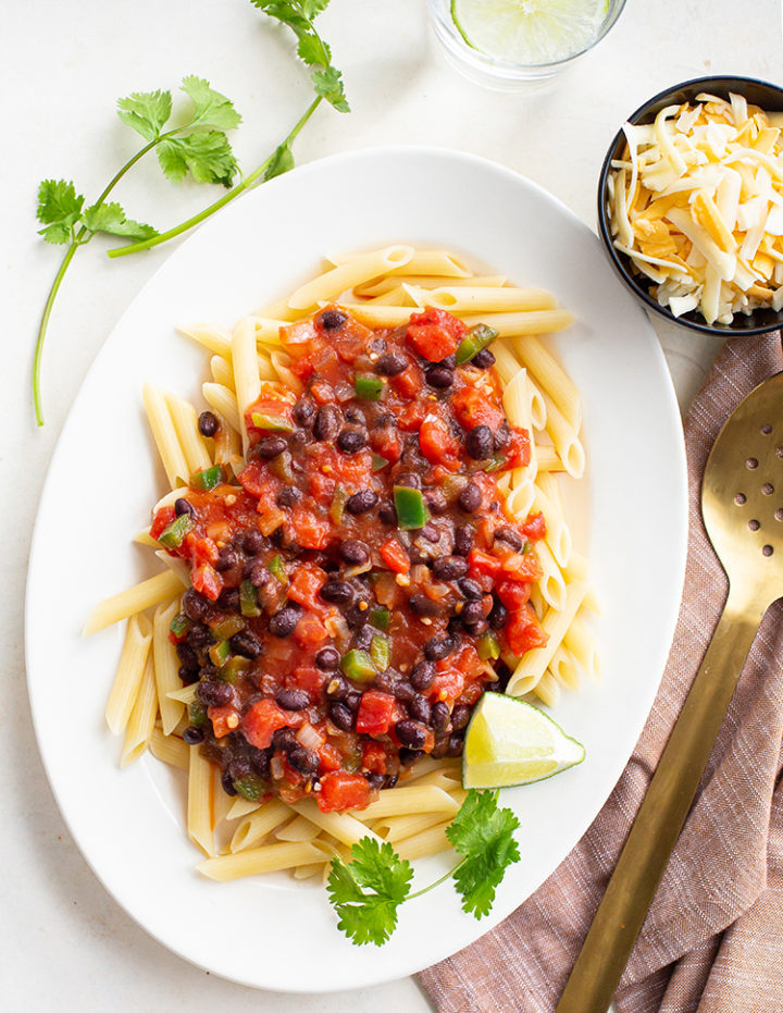 overhead shot of pasta with a black bean sauce on a white platter